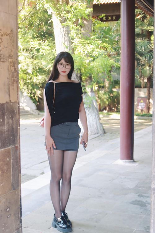 Free A young woman stands confidently in a summer outfit at a traditional Nanjing location. Stock Photo
