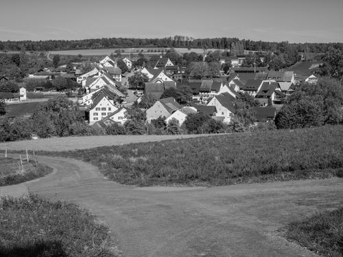 Free A scenic black and white view of a picturesque rural village with fields and paths. Stock Photo