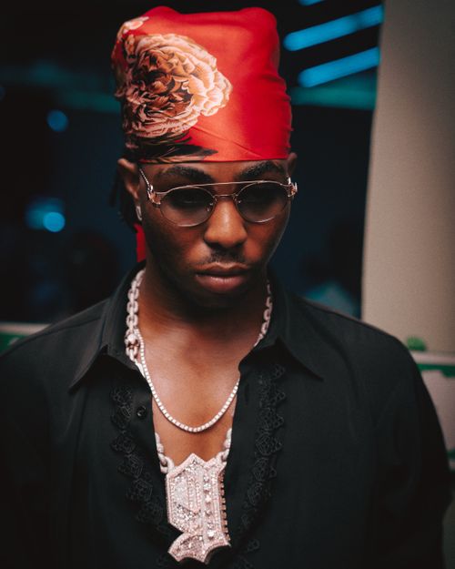 Free Portrait of a stylish man wearing a red bandana and sunglasses under city lights. Stock Photo