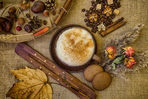 Free A warm autumn-themed flat lay featuring coffee, spices, leaves, and flowers on burlap. Stock Photo