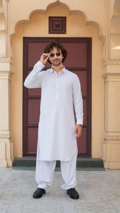 Free Adult male wearing a traditional white kurta with sunglasses, posing confidently outdoors. Stock Photo