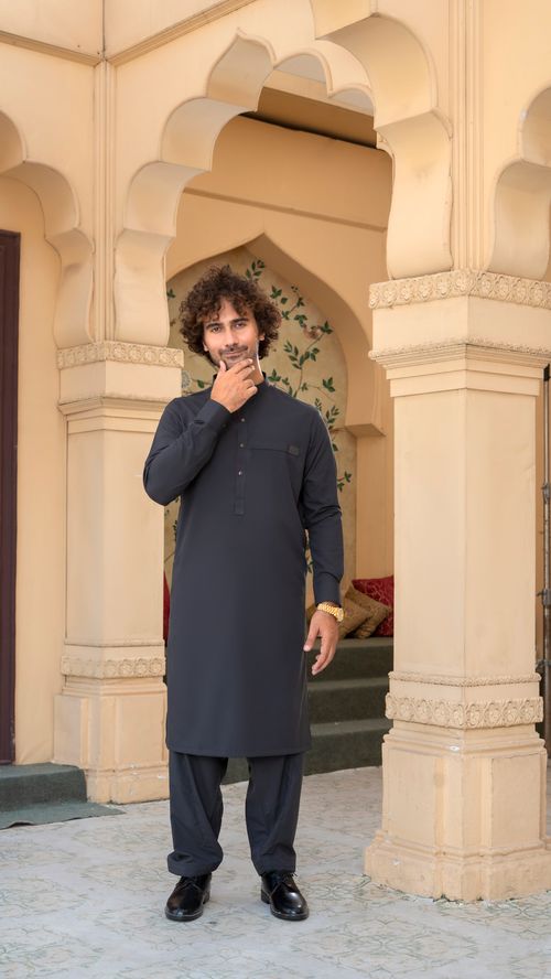 Free A man in traditional attire stands confidently in a decorative archway, exuding cultural charm. Stock Photo