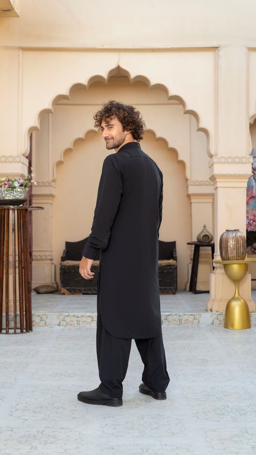 Free A man in traditional attire stands in an ornate architecture setting, capturing cultural elegance. Stock Photo