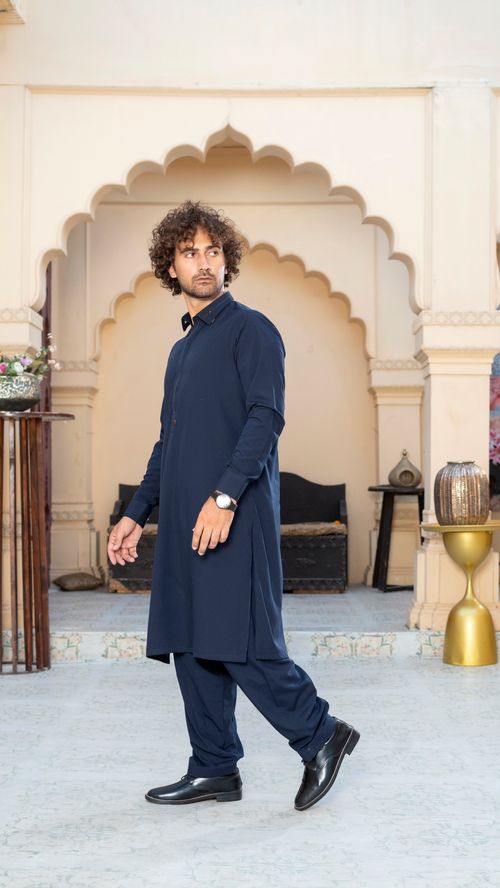Free A man in a blue traditional kurta walking indoors with elegant decor showcasing cultural fashion. Stock Photo