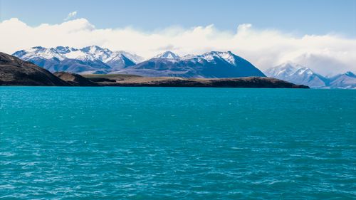 Free Breathtaking scene of Lake Tekapo's turquoise waters with the snowy peaks of the Southern Alps in New Zealand. Stock Photo