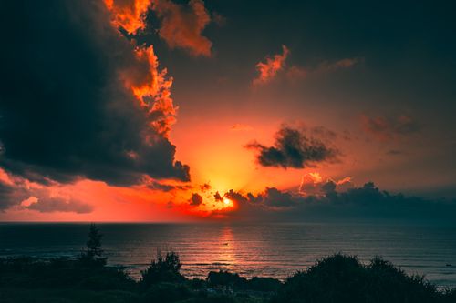 Free A dramatic sunset at Cửa Tùng Beach, Vietnam, with vibrant orange skies and dark clouds. Stock Photo