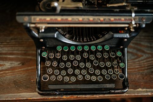 Free Old-fashioned typewriter featuring Cyrillic keys on a wooden desktop. Perfect for retro and vintage themes. Stock Photo