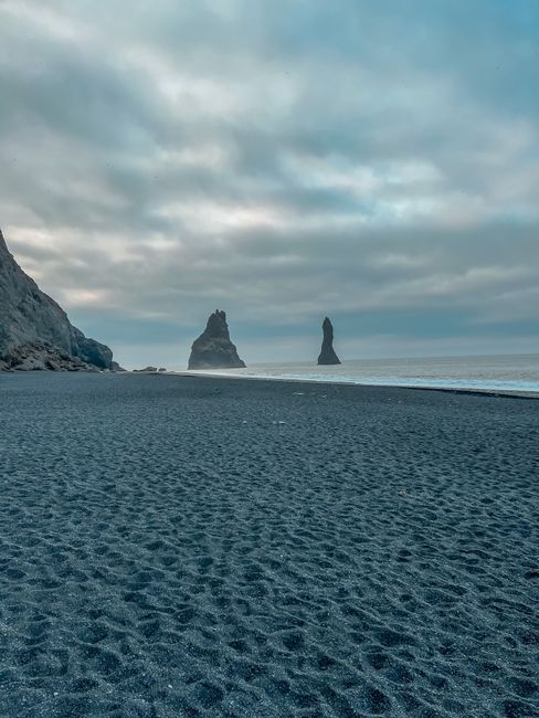 Fotomural Vista majestuosa de las pilas de mar de Reynisdrangar en un día nublado en la playa de Vík í Mýrdal, Islandia.