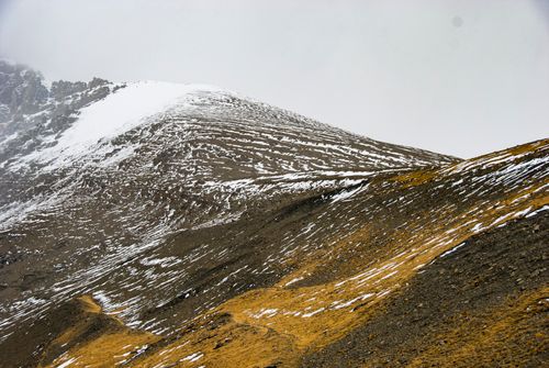 Free Serene view of a snow-dusted mountain with barren earth, captured in a winter setting. Stock Photo