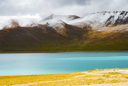 Free Serene blue lake surrounded by majestic snow-covered mountains in autumn season. Stock Photo