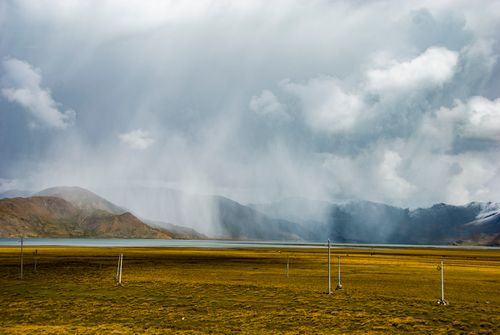 Free Breathtaking view of a mountain landscape with showers under a dramatic sky. Stock Photo