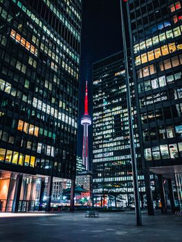 Stunning Toronto cityscape at night featuring the iconic CN Tower illuminated against modern skyscrapers.