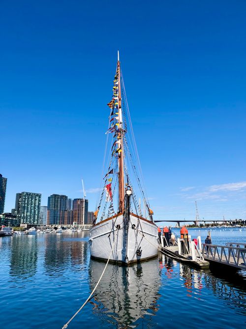 Free Colorful sailing ship docked at Docklands, Melbourne with city skyline in the background. Stock Photo