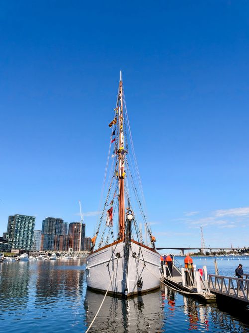 Free Sailboat docked at Docklands with the Melbourne skyline in the background on a clear day. Stock Photo