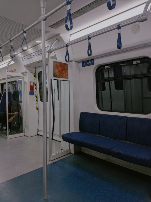 Free Interior view of an empty train compartment in Bukit Mertajam, showcasing blue seats and handrails. Stock Photo