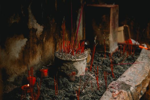 A serene display of incense sticks and candles in an Asian temple setting, creating a meditative atmosphere.