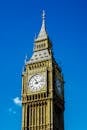 在晴朗的蓝天下，英国伦敦的大本钟展现出其标志性建筑的醒目景色