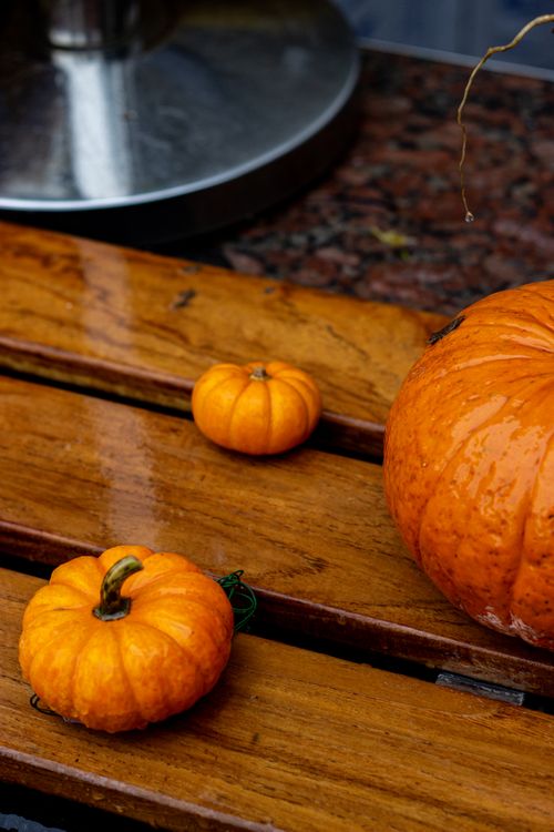 Free A close-up view of bright orange pumpkins on a wooden surface, capturing the essence of autumn. Stock Photo
