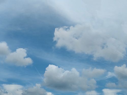 Free Serene view of a vibrant blue sky filled with fluffy white clouds on a sunny day. Stock Photo