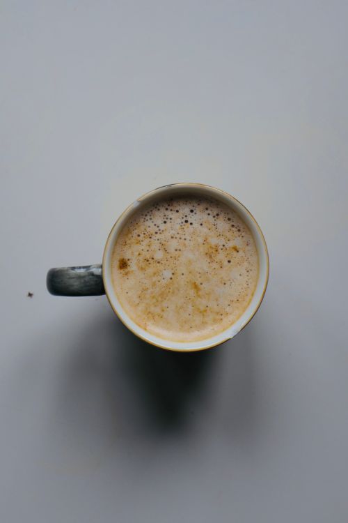 Free Delicious cappuccino with frothy milk foam in a rustic mug, perfect for coffee lovers. Stock Photo