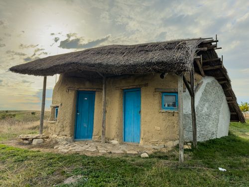 Free A traditional rustic house with a thatched roof and blue doors in Jurilovca, Romania. Stock Photo