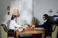 Couple Reaching for Bread