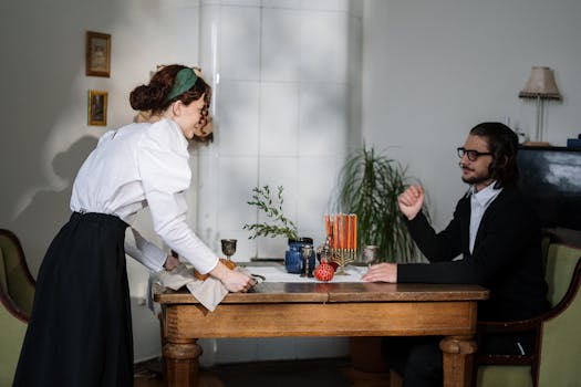 A couple celebrating a cultural tradition at home with festive table settings.