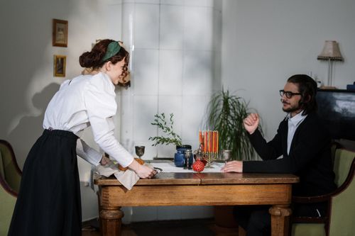 Free A couple celebrating a cultural tradition at home with festive table settings. Stock Photo