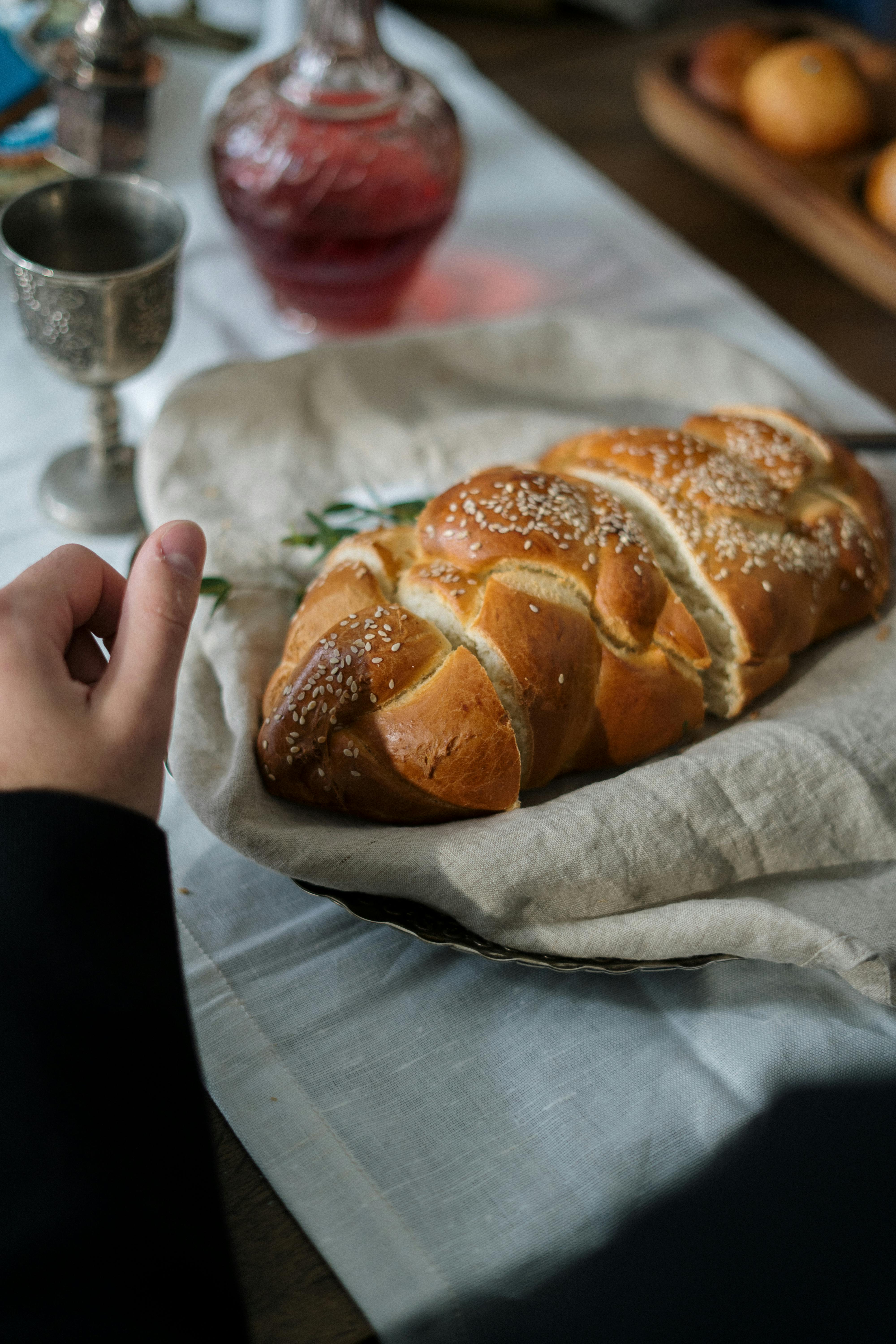 A beautifully set table featuring a traditional braided challah bread for Shabbat celebration.