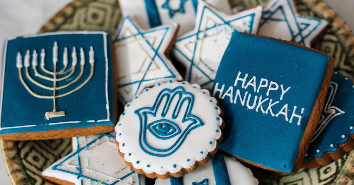 Decorative cookies featuring Hanukkah symbols like the menorah, Star of David, and Hamsa on a patterned plate.