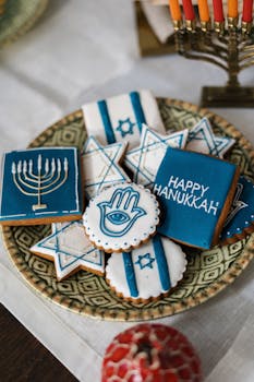 Decorative cookies featuring Hanukkah symbols like the menorah, Star of David, and Hamsa on a patterned plate.