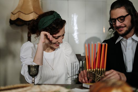 A joyous couple celebrating Hanukkah at home, lighting a menorah.