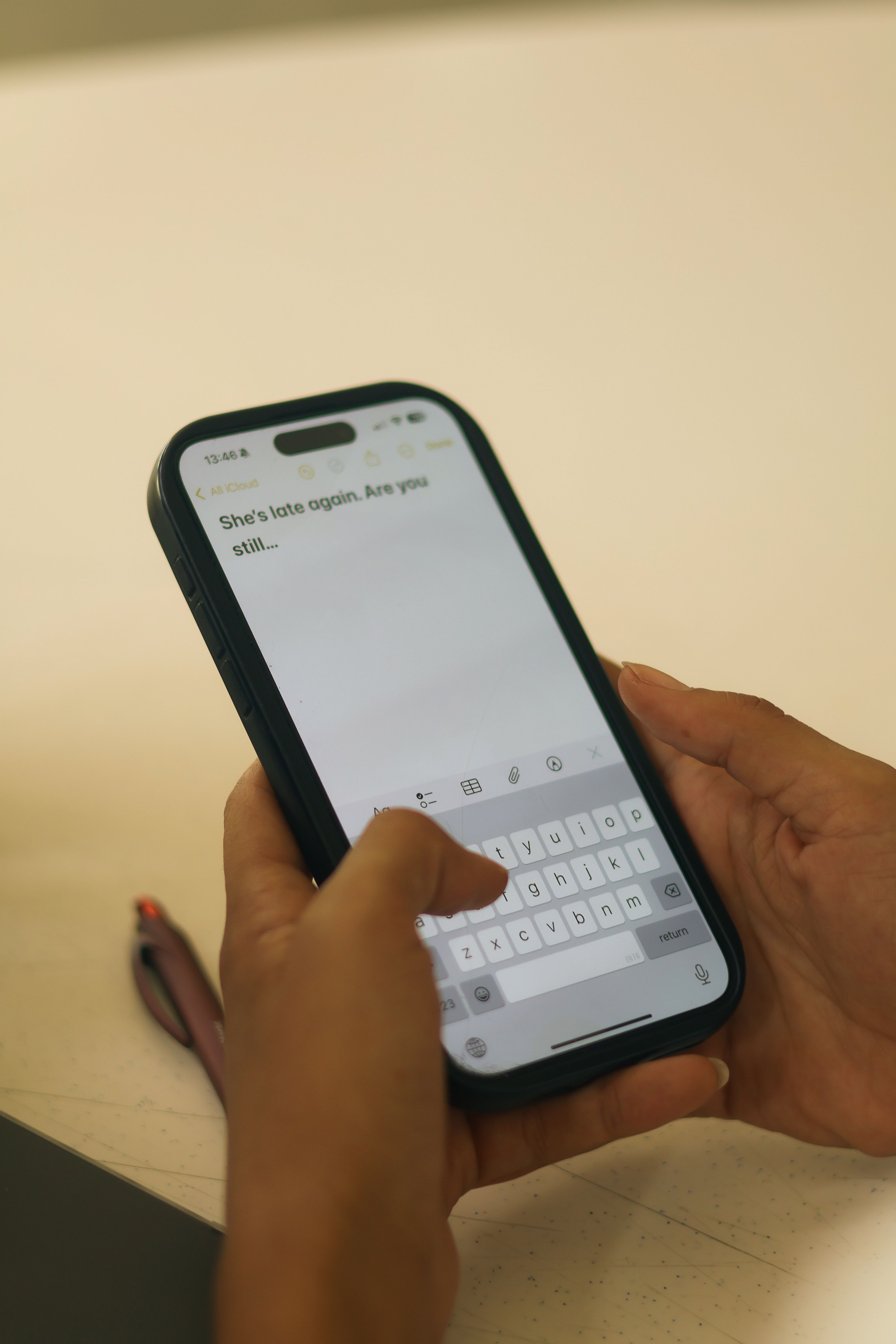 Close-up of hands typing a text message on a smartphone