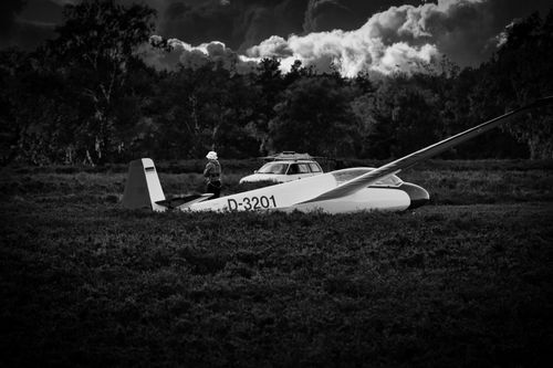 Free Monochrome image of a glider and car in a forest clearing at daytime. Stock Photo