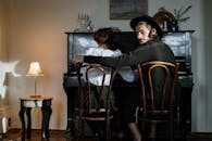 一对年轻的东正教夫妇在舒适的家庭环境中，坐在钢琴旁共同创作音乐