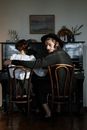 Woman in Black Jacket Sitting on Brown Wooden Chair