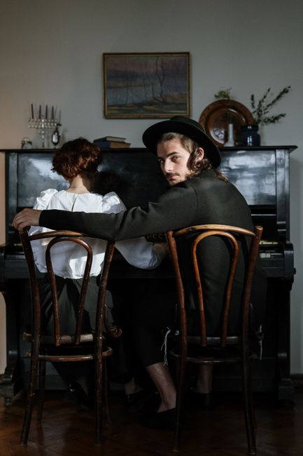 A couple sitting together at a piano, evoking love and music in a cozy home environment.