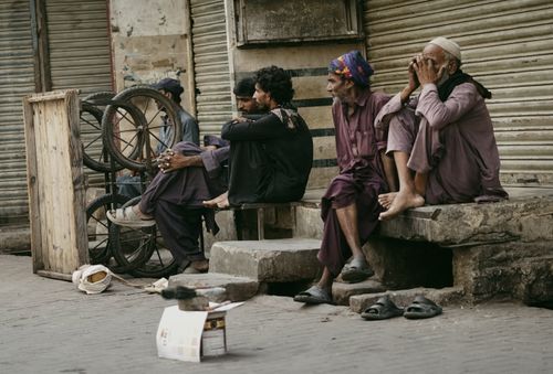 Free Candid capture of men sitting in an urban setting, highlighting daily street life. Stock Photo
