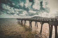 在多云的日落天空下，延伸到海洋的码头呈现出戏剧性的宁静海景