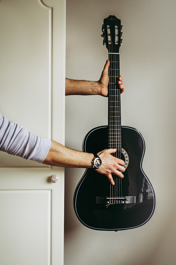 A Holding A Black Guitar