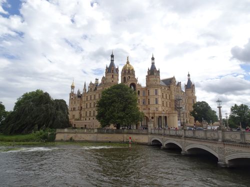 Free A beautiful view of the historic Schwerin Castle by the lake, under a cloudy sky in Germany. Stock Photo