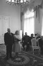 Elegant bride with groom in suit standing during wedding ceremony