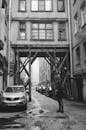 Grayscale Photo of Man Standing Outside The Street