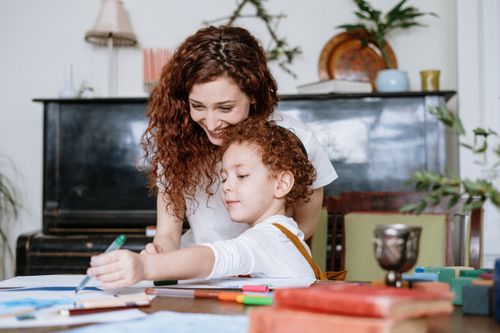 Free A loving mother and her child enjoy drawing together at home, fostering creativity and family bonding. Stock Photo