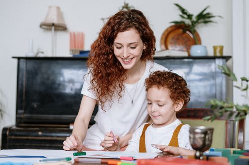 Free A mother and son enjoy a bonding moment indoors, creating art together with a cozy home atmosphere. Stock Photo