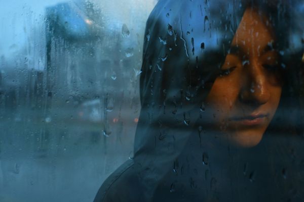 Une femme triste derrière une vitre