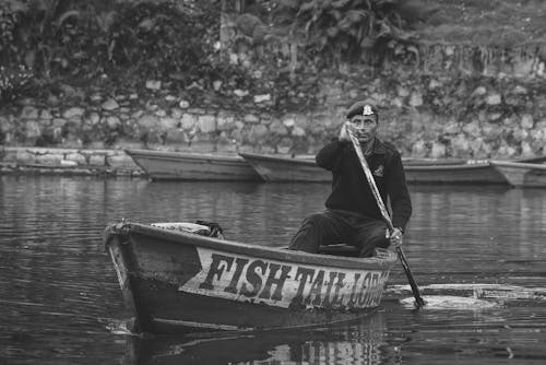 Grayscale Photo of Man in the Boat