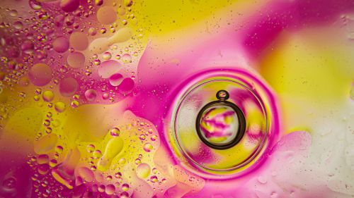 Free Vivid abstract image of oil and water bubbles with vibrant pink and yellow colors. Stock Photo