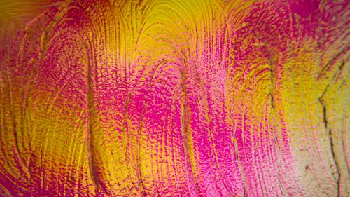 Free Close-up of textured abstract art in vivid pink and yellow hues, showcasing brushstroke details and dynamic patterns. Stock Photo