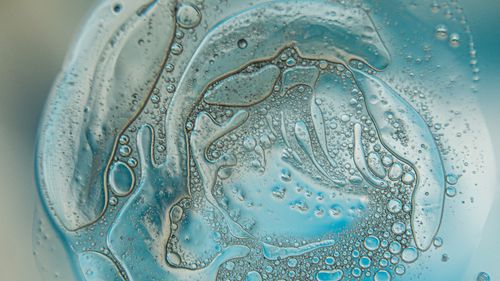 Free Close-up abstract image of bubbles in a blue liquid, showcasing intricate patterns and textures. Stock Photo